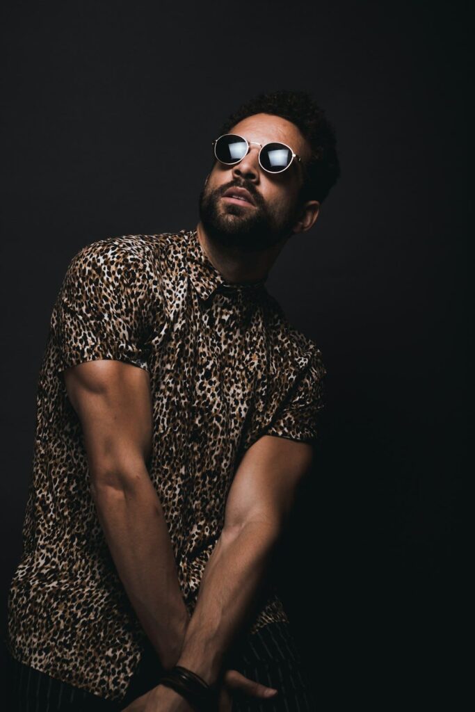 man-wearing-brown-and-black-leopard-print-button-up-t-shirt-and-black-sunglasses-crossing-hands-down-while-looking-up-vknryw-mtek Image Service 4 Produits